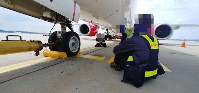 공항 지상조업 노동자에게 연장노동은 일상이다. 근로기준법 59조에 따른 특례업종이라 사용자가 근로자 대표와 서면합의를 하면 근로시간을 사실상 무제한으로 늘릴 수 있기 때문이다. 사진은 비행기 날개 밑 그늘에서 쉬고 있는 인천국제공항 지상조업 노동자. 공공운수노조 제공