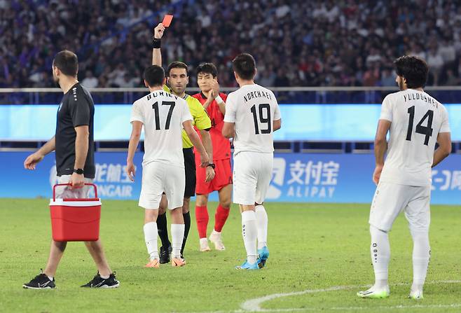 우즈베키스탄 부리예프가 조영욱에게 거친 태클로 경고를 받은 뒤 경고누적으로 퇴장당하고 있다. /연합뉴스