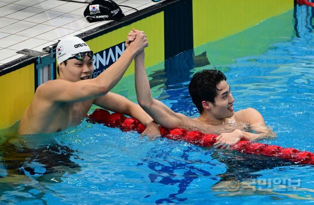 황선우가 27일 중국 항저우 올림픽 스포츠센터 수영장에서 열린 항저우아시안게임 수영 남자 자유형 200m 결승에서 금메달을 확정한 뒤 3위를 차지한 이호준과 기뻐하고 있다. 항저우=이한형 기자