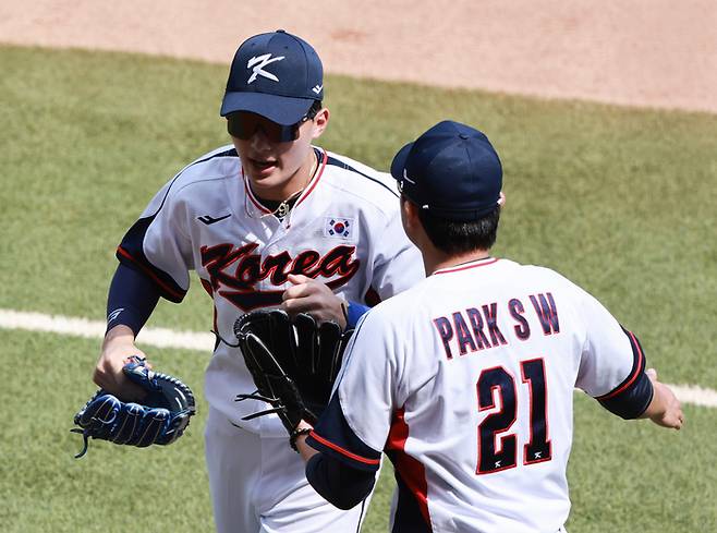 5일 중국 저장성 항저우 인근 사오싱 야구·소프트볼 스포츠센터 제1구장에서 열린 2022 항저우 아시안게임 슈퍼라운드 일본과 대한민국의 경기. 2회초를 마치며 대한민국 선발 투수 박세웅이 더그아웃에 들어오는 윤동희를 격려하고 있다. 사진 | 샤오싱=연합뉴스