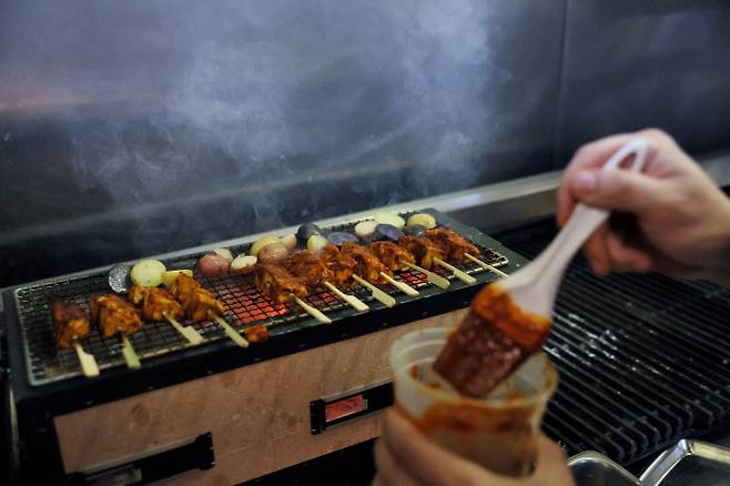 지난 7월13일(현지시간) 미국 워싱턴에 있는 유명 레스토랑 ‘차이나 칠카노’에서 한 셰프가 닭고기 배양육에 소스를 발라 굽고 있다. 로이터연합뉴스