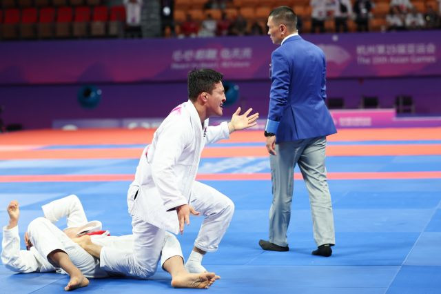 한국 주짓수 국가대표 구본철이 6일 중국 항저우 샤오산 린푸 체육관에서 열린 아시안게임 남자 77㎏급 결승전에서 바레인의 압둘라 문파레디를 상대로 승리를 확정한 뒤 환호하고 있다. 연합뉴스