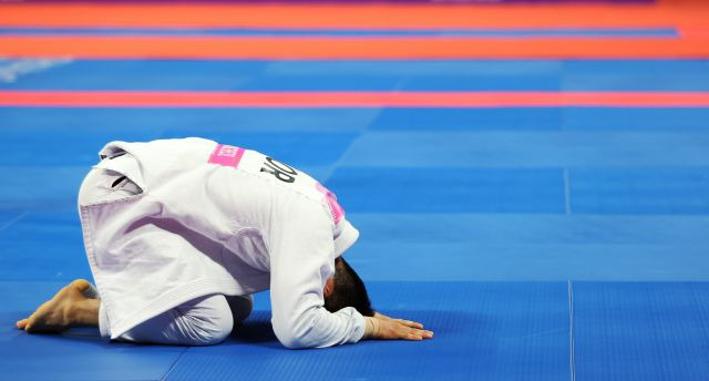 한국 주짓수 국가대표 구본철이 6일 중국 항저우 샤오산 린푸 체육관에서 열린 아시안게임 남자 77㎏급 결승전에서 금메달을 확정한 뒤 바닥에 엎드려 감격하고 있다. 연합뉴스