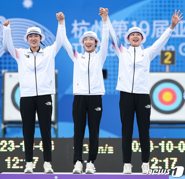 안산(왼쪽부터), 최미선 임시현이 6일 양궁 리커브 여자 단체전 시상식에서 손을 맞잡고 시상대에 오르고 있다. /사진=뉴스1