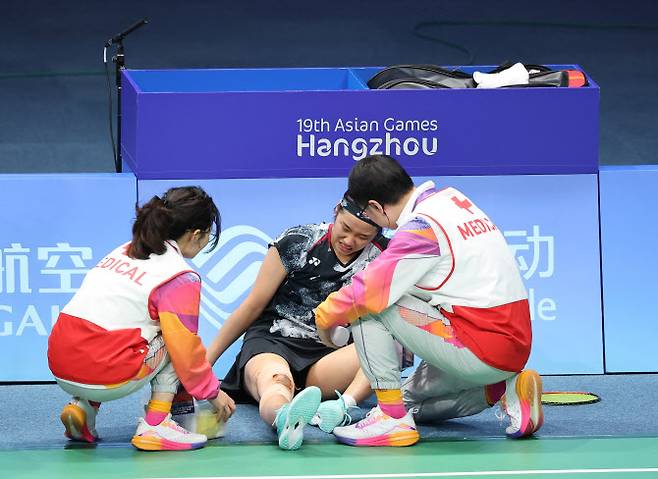 안세영이 1세트 경기 도중 무릎에 이상을 느껴 의료진으로부터 응급치료를 받고 있다. (사진=연합뉴스)