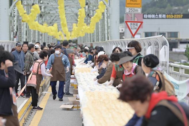 '가장 긴 인절미 만들기' 한국기록 도전   (공주=연합뉴스) '2023 대백제전' 세부 프로그램으로 7일 충남 공주시 금강철교 위에서 열린 '인절미 축제'에서 시민과 관광객들이 인절미를 만들고 있다. 공주시는 이 축제에서 '단일 장소에서 동시에 만들어진 가장 긴 인절미' 부문 한국기록원 공식 최고 기록을 수립했다고 밝혔다. 2023.10.7 [공주시 제공. 재판매 및 DB 금지]