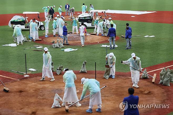 결승 앞두고 내린 비로 그라운드 정비하는 관계자들 (사오싱[중국]=연합뉴스) 신현우 기자 = 7일 중국 저장성 항저우 인근 사오싱 야구·소프트볼 스포츠센터 제1구장에서 2022 항저우 아시안게임 결승, 대만과 대한민국의 경기에 앞서 비가 내려 대회 관계자들이 그라운드 정비를 하고 있다.
    이날 비로 인해 경기가 연기되면 8일 열리고, 8일에도 열리지 못할 경우 조별리그에서 대만에 진 대한민국은 은메달에 머물게 된다. 2023.10.7 nowwego@yna.co.kr