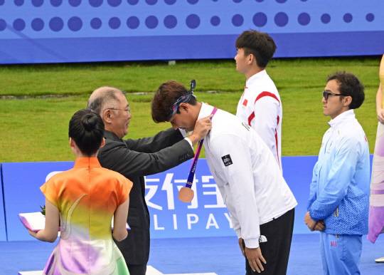 정의선 현대자동차그룹 회장(대한양궁협회장)이 중국 항저우 아시안게임에서 금메달을 딴 이우석 선수에게 메달을 걸어주고 있다. 대한양궁협회 제공