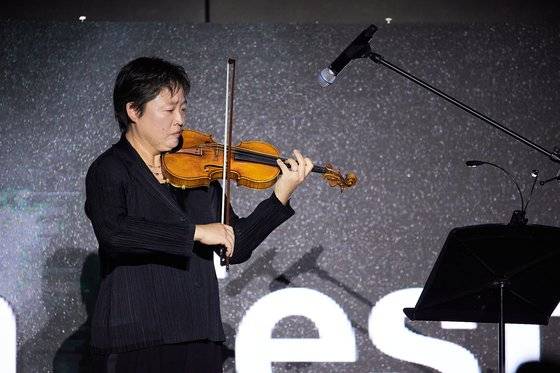 4일 열린 제28회 부산국제영화제 개막식에서 고 윤정희 배우를 대신해 한국영화공로상을 받은 딸 백진희 씨가 바이올린을 연주하고 있다. 사진 부산국제영화제