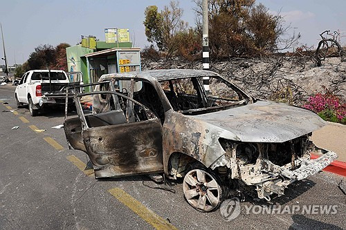 이스라엘 남부 스데로트 인근 도로에 하마스 무장대원의 공격을 받아 불에 탄 차량이 서 있다. [AFP 연합뉴스 자료사진. 재판매 및 DB 금지]