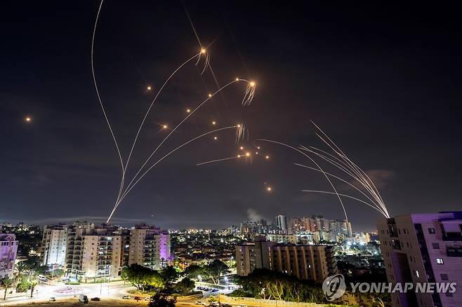 팔레스타인 가자지구에서 날아온 로켓포탄(오른쪽)과 이를 요격하기 위해 방공망 아이언돔에서 발사된 요격 미사일(오른쪽)의 궤적. [로이터 연합뉴스 자료사진. 재판매 및 DB 금지]