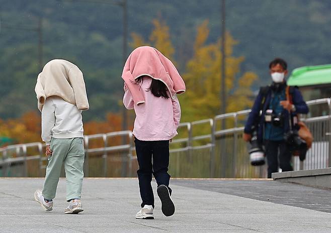 8일 오후 서울 광화문광장을 찾은 어린이들이 비가 내리자 겉옷을 머리에 쓴 채 길을 지나고 있다. 연합뉴스