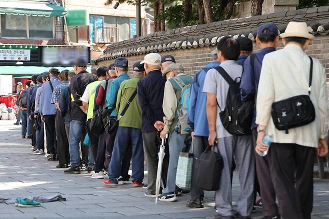 지난 1일 서울 종로구 원각사 노인무료급식소 앞에 점심식사를 기다리는 노인들이 길게 줄을 서 있다. 사진=연합뉴스