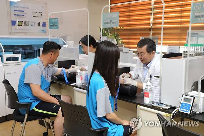 병역판정검사 전 과정 체험 행사 (서울=연합뉴스) 국방부 관계자가 5일 서울 영등포구 서울지방병무청에서 병무정책 이해도 제고를 위해 진행된 병역판정검사 전 과정 체험에서 채혈하고 있다. 2023.7.5 [병무청 제공. 재판매 및 DB 금지] photo@yna.co.kr