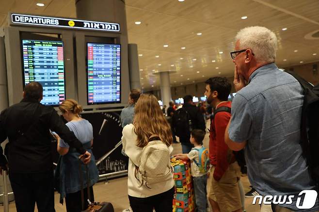 7일(현지시간) 이스라엘 텔아비브의 벤 구리온 국제 공항에서 승객들이 항공편 게시판을 바라보고 있다. 이날 이스라엘에서는 하마스의 대규모 공격을 받아 비행편이 잇따라 취소되거나 축소됐다. 2023.10.07/ ⓒ AFP=뉴스1 ⓒ News1