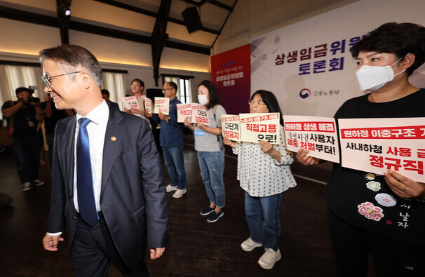 지난 5월23일 오후 서울 중구 정동1928아트센터에서 열린 상생임금위원회 토론회에 이정식 고용노동부 장관이 참석한 가운데 비정규직 임금 대폭 인상, 노동시장 이중구조 해결 등을 촉구하는 기습시위가 진행되고 있다. 연합뉴스