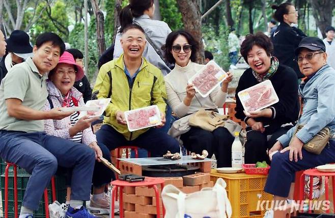 축제장을 찾은 한 가족이 밝은 표정으로 저렴하게 구입한 한우세트를 들어보이고 있다.