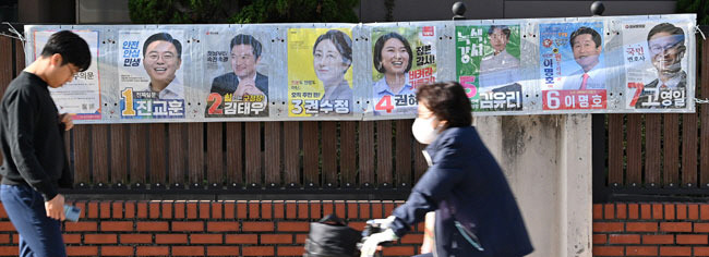 누가 웃을까　   서울 강서구청장 보궐선거를 하루 앞둔 10일 오전 한 시민이 서울 강서구 화곡동 일대에 붙은 후보들의 벽보판 앞을 지나가고 있다.  백동현 기자