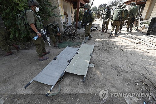 이스라엘 군인들이 10일(현지시간) 팔레스타인 가자지구 인근에 있는 크파르 아자 키부츠에서 살해된 이스라엘인들의 시신을 수습하는 작업을 하고 있다.  [크파르 아자 EPA=연합뉴스]