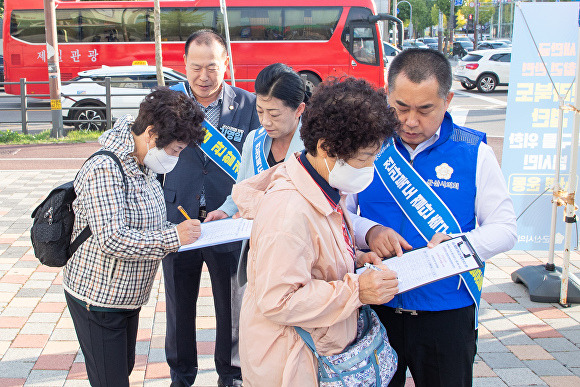 김영일 군산시의회 의장을 비롯한 의원들이 가두 서명운동을 펴고 있다. [사진=군산시의회 ]