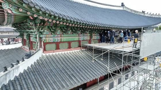 광화문 월대 및 현판 복원 기념식을 사흘 앞둔 12일 오후 서울 광화문에서 관계자들이 흰색 바탕에 검은색 글자로 된 광화문 현판을 철거하고 있다.   연합뉴스