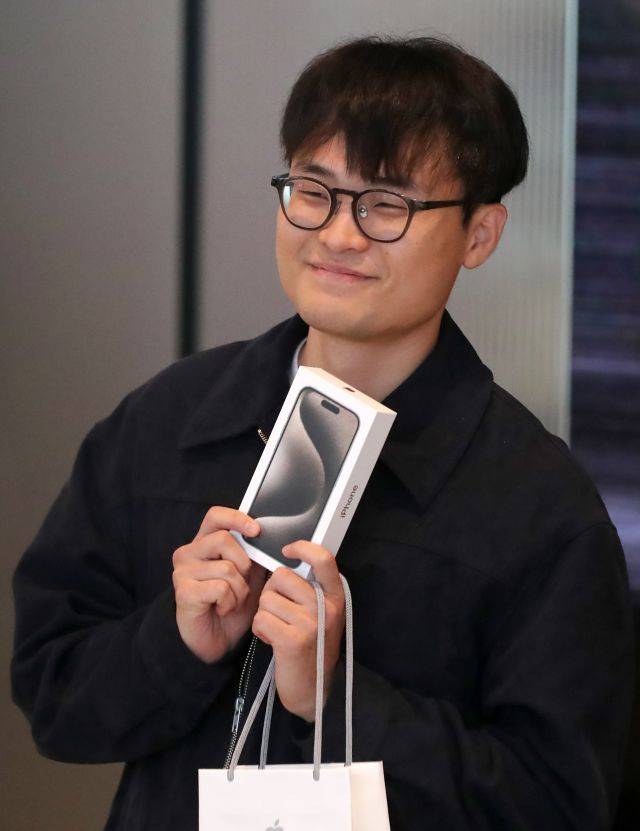 아이폰15 시리즈 출시 첫날인 13일 서울 중구 애플스토어 명동점에서 1호 수령자 김민재 씨가 아이폰15를 들고 기념사진을 촬영하고 있다. 연합뉴스