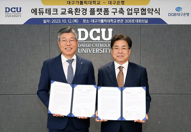 12일 대구가톨릭대학교에서 열린 플랫폼 구축 업무협약식에 참석한 황병우(왼쪽) 대구은행장과 성한기(오른쪽) 대구가톨릭대 총장이 기념촬영을 하고 있다.[DGB대구은행 제공]