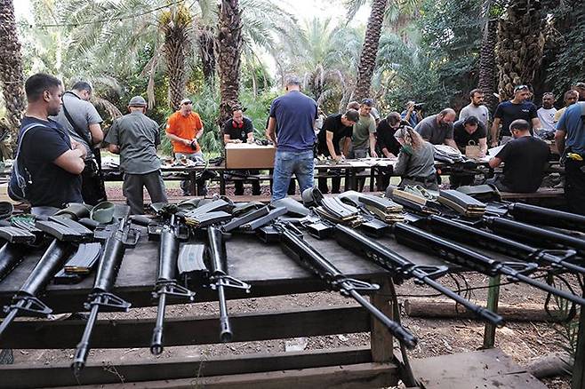 이스라엘, 주민들에 총기 지급 - 12일(현지 시각) 이스라엘 북부 국경 인근의 한 키부츠(집단농장)에서 이스라엘 주민들이 소총을 비롯한 무기를 지급받고 있다. 이날도 이스라엘 남쪽 가자지구와 북쪽 레바논, 시리아 국경 인근 등에서 로켓·미사일 공습과 교전이 이어지면서 양측 사망자가 2500명을 넘었다. /AFP 연합뉴스