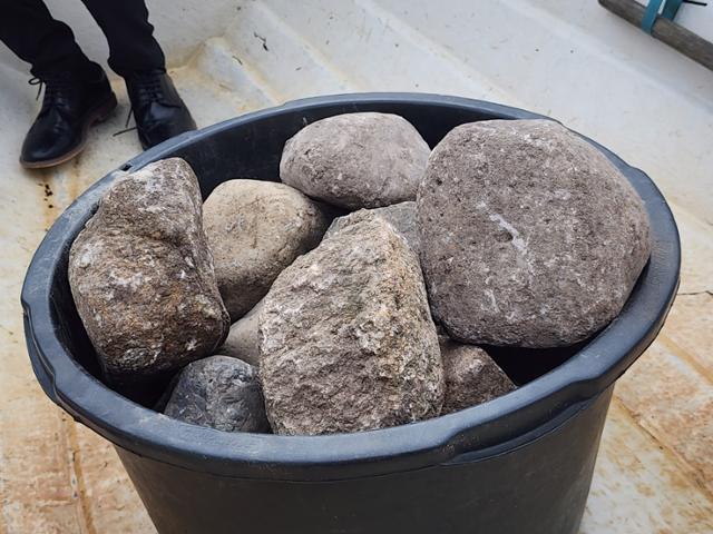 덴마크 북부에 위치한 올보르의 레세 프리만 옌슨 시장이 지난달 10일 림 피오르드로 돌을 던지기 전, 돌덩이들이 통에 수북이 담겨 있다. 올보르(덴마크)=신은별 특파원