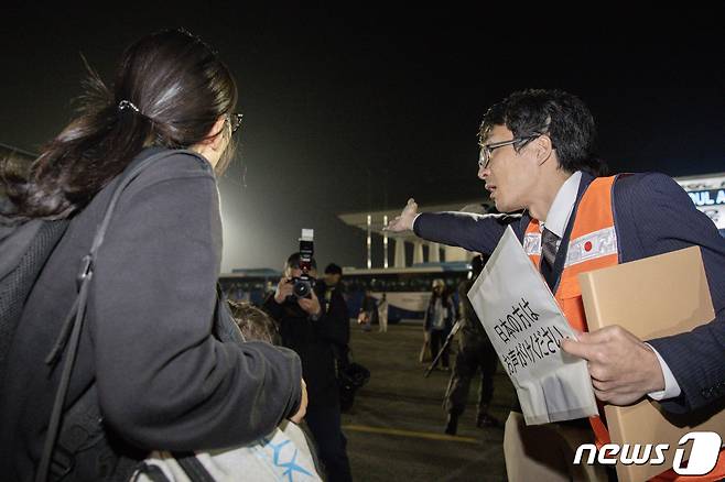 14일 밤 이스라엘에서 출발해 경기 성남 서울공항에 도착한 일본인에게 주한일본대사관 직원이 수속 안내를 하고 있다. 구조 인원은 우리 국민 163명과 일본인 51명, 싱가포르인 6명 등 총220이다. 2023.10.15/뉴스1 ⓒ News1 사진공동취재단