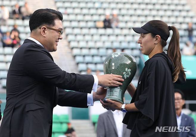 [서울=뉴시스] 황준선 기자 = 15일 오후 서울 송파구 올림픽공원 테니스장에서 열린 여자프로테니스(WTA) 투어 하나은행 코리아오픈 2023 단식 결승전에서 우승을 차지한 미국 제시카 페굴라가 이은형 하나금융그룹 부회장에게 트로피를 수여받고 있다. 2023.10.15. hwang@newsis.com