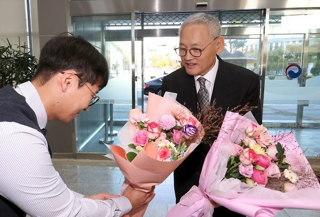 유인촌 문화체육관광부 장관이 16일 오전 세종시 정부세종청사로 출근하며 직원들로부터 꽃다발을 받고 있다(사진=연합뉴스).