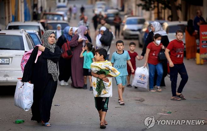 피난길에 오른 팔레스타인 여성과 어린이 (가자시티 AFP=연합뉴스) 팔레스타인 여성들과 어린이들이 13일(현지시간) 가자지구 중심 도시 가자시티에서 짐을 챙겨 더 안전한 지역으로 피신하고 있다. 이스라엘은 팔레스타인 무장 정파 하마스와의 무력 충돌 이레째인 이날 가자시티 주민 전원에게 대피령을 내렸다. 2023.10.13 besthope@yna.co.kr