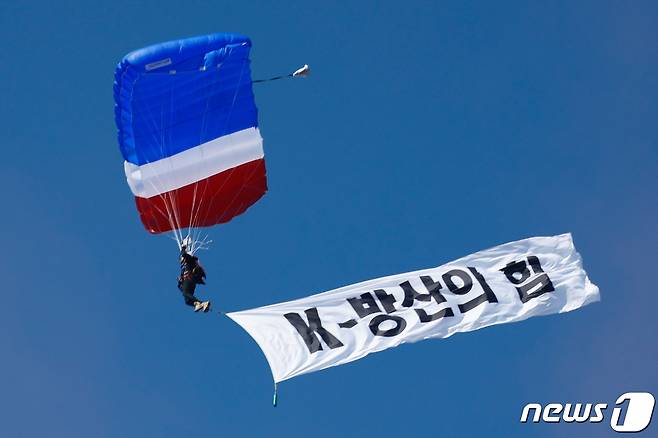 16일 경기 성남시 서울공항에서 열린 서울 국제 항공우주·방위산업 전시회(ADEX) 2023 프레스 데이에서 열린 한미 공군 연합작전 시범에서 우리 공군이 낙하산을 매고 'K-방산의 힘' 현수막을 펼친 채 하강하고 있다. 2023.10.16/뉴스1 ⓒ News1 안은나 기자