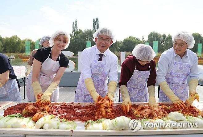 박강수 마포구청장이 2022년 10월 열린 마포나루 새우젓축제에서 외국인 참가자들과 김장 담그기 체험을 함께하고 있다.ⓒ연합뉴스