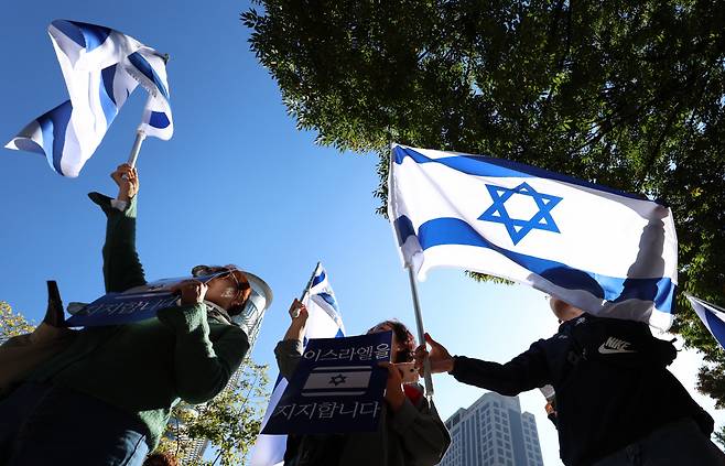 Demonstrators hold up Israel's national flag and a sign that reads "Support Israel" during the Solidarity with Israel rally held near Gwanghwamun Station in central Seoul, Tuesday. (Yonhap)