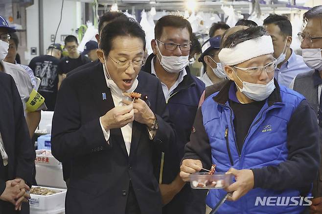 [도쿄=AP/뉴시스]러시아가 일본산 수산물 수입을 금지하자, 17일 일본 각료들은 부당하다고 항의하고 철회할 것을 요구했다. 사진은 기시다 총리(오른쪽)가 지난 8월 31일 일본 도쿄의 도요스 수산시장을 찾아 해산물을 맛보고 있는 모습. 2023.10.17.