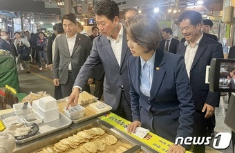 이영 중소벤처기업부 장관(왼쪽)이 18일 부산 수영팔도시장에 방문해 온누리상품권으로 장을 보며 상인과 소통하고 있다. ⓒ News1 이민주 기자