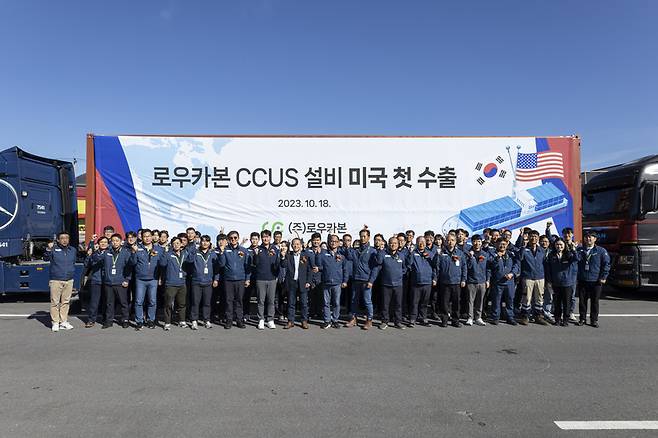 전남 강진군에 위치한 로우카본 본사에서 CCUS 설비 미국 첫 수출 차량 앞에서 직원들이 기념사진을 찍고 있다. / 사진=로우카본 제공