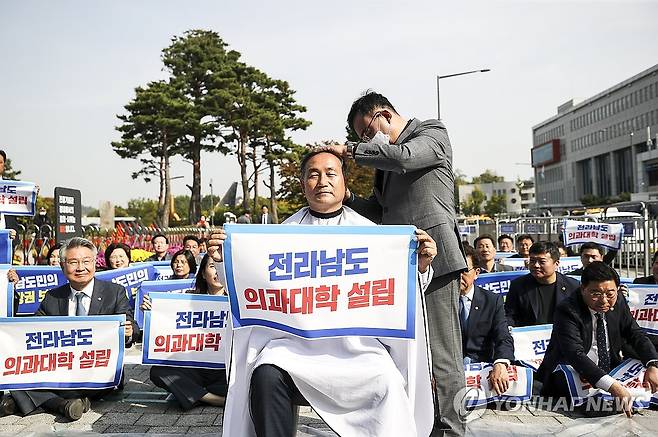 대통령실 앞 전남 의대 설립 촉구 삭발 (서울=연합뉴스) 류영석 기자 = 18일 오후 서울 용산 대통령실 앞에서 열린 전라남도 의과대학 신설 촉구대회에서 더불어민주당 김원이 의원이 삭발을 하고 있다. 2023.10.18 [공동취재] ondol@yna.co.kr