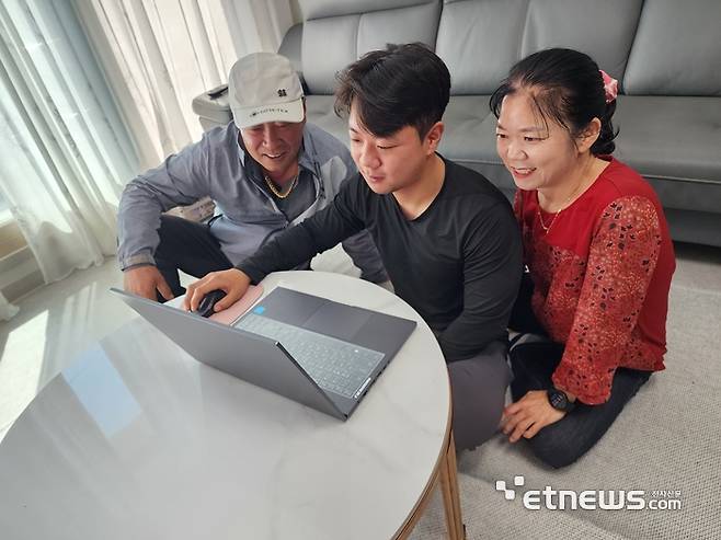 김정돌 서해수산 대표(왼쪽)가 아들, 아내와 함께 KT 초고속인터넷망 구축후 빠른 속도로 구현되는 노트북을 보고 있다.
