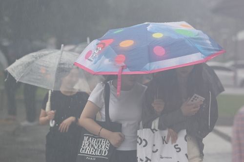 서울시청 인근에서 우산을 쓴 시민들이 이동하고 있다. [사진 제공 = 연합뉴스]