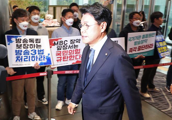 국회 과학기술정보방송통신위원회의 MBC에 대한 국정감사가 열린 19일 오전 장제원 과방위원장이 서울 마포구 MBC 건물로 들어서고 있다. 장제원 위원장 뒤로 MBC 노조와 제3노조 조합원들이 각각 다른 내용의 피켓을 들고 서 있다. [연합]