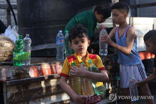 트럭에서 식수 받아가는 팔레스타인 어린이들 [AFP=연합뉴스]