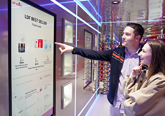 Foreign visitors explore Lotte Duty Free items at LDF House in Myeong-dong, central Seoul. [LOTTE DUTY FREE]