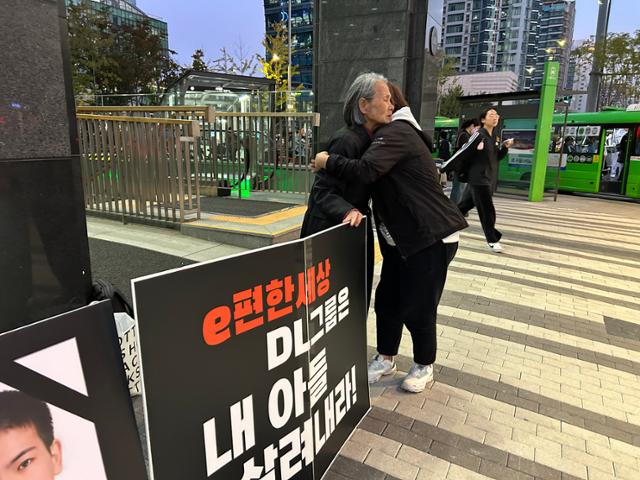 한 시민이 16일 오후 서울 종로구 DL이앤씨 본사 앞에서 1인 시위 중인 이숙련씨에게 두유를 건네며 안아주고 있다. 남보라 기자