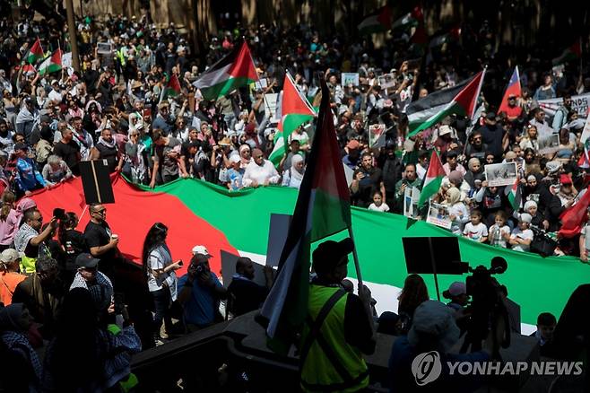 호주 시드니 팔레스타인 지지 시위 (시드니 로이터=연합뉴스) 21일(현지시간) 호주 시드니에서 열린 팔레스타인 지지 시위에서 참석자들이 대형 팔레스타인 국기를 펼쳐 들고 행진하고 있다. 2023.10.21. photo@yna.co.kr