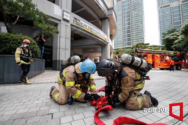 지난 6월 서울 강남구 타워팰리스에서 열린 '초고층 건축물 민간 자율주도 소방훈련'에서 소방대원들이 전기차 화재진압 훈련을 하고 있다. 사진=강진형 기자aymsdream@