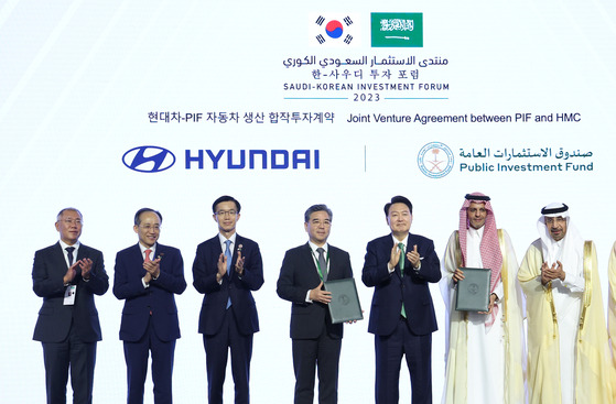 Hyundai Motor Group Executive Chair Euisun Chung, far left, Korean President Yoon Suk Yeol, fifth from left, and Yazid Alhumied, deputy governor of Saudi Arabia's Public Investment Fund (PIF), second from right, clap hands on Sunday as Hyundai Motor and the PIF signed a partnership to build an auto assembly plant in the Middle East country. [YONHAP]