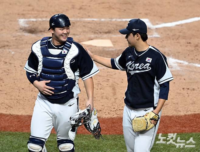 지난 2022 항저우아시안게임 당시 포수 김형준(왼쪽)이 문동주(오른쪽)와 대화하며 덕아웃으로 향하고 있다. 황진환 기자